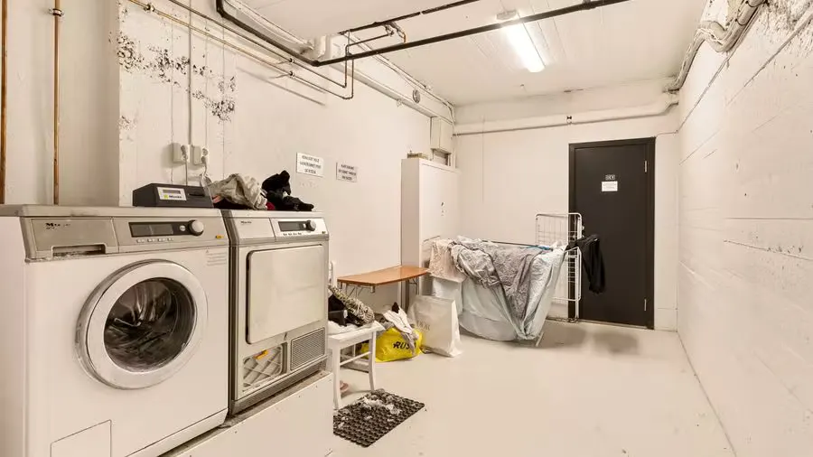 Spacious laundry room featuring washing machine and dryer with visible piping.